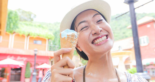 Close-up portrait of smiling woman holding ice cream