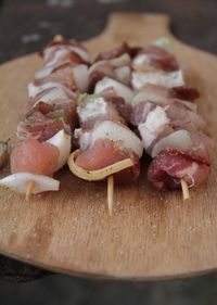 Raw beef skewers on cutting board