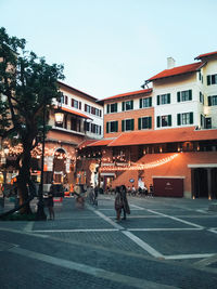 People walking on street against buildings in city