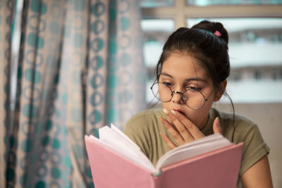 Side view of young woman reading book