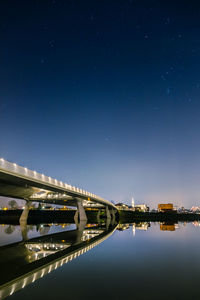 Illuminated bridge against sky at night