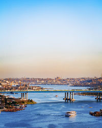 Bridge over river in city against clear sky during sunset in istanbul