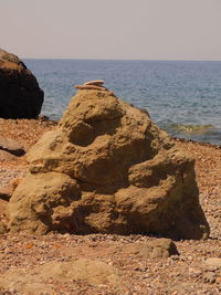 Rock formation on beach against clear sky