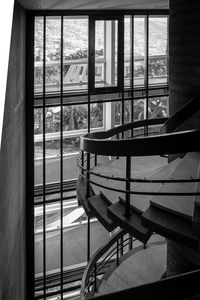 Empty chairs and table by window in building