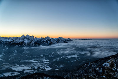 Scenic view of snowcapped mountains against clear sky during sunset