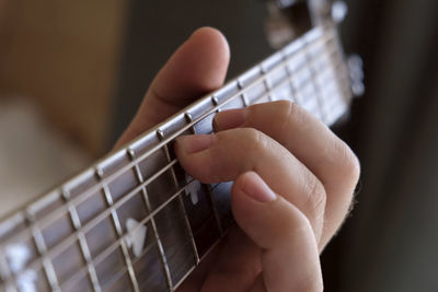 Man playing guitar chord. strumming acoustic guitar. male fingers and fretboard closeup. guitar neck