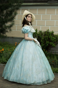 Portrait of young woman standing against trees