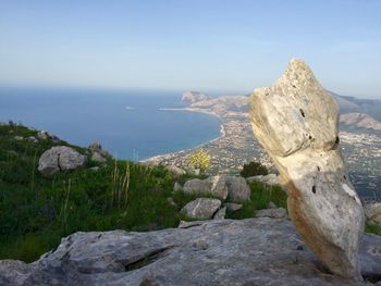 Rock formation and seascape against sky