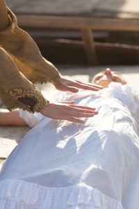 Cropped hands of woman touching friend