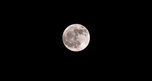 Low angle view of full moon against clear sky at night