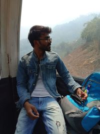 Portrait of young man sitting on sofa
