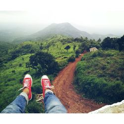 Low section of person sitting over landscape