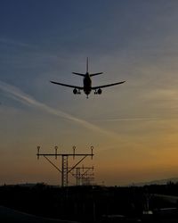 Silhouette airplane against sky at sunset