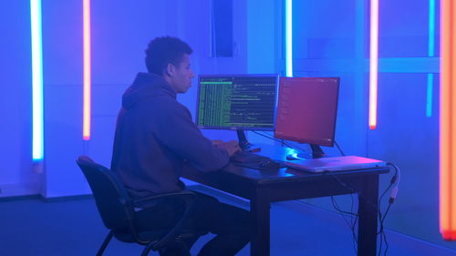 Side view of man working on table