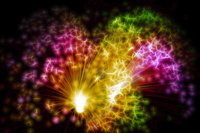 Low angle view of illuminated firework display at night