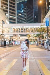 Full length of woman standing on road in city