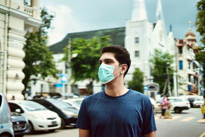 Portrait of young man on street in city