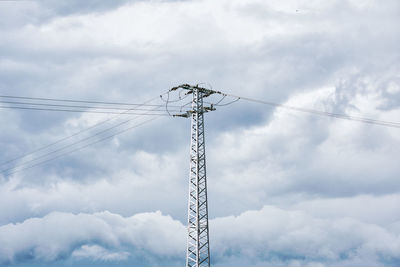 Low angle view of electricity pylon against sky