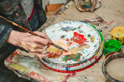 The artist's hand with a brush in his hand in an art studio. bright colors