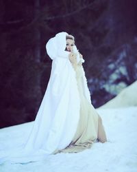 Portrait of fashionable woman standing on snow field