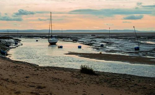 Boats in sea at sunset