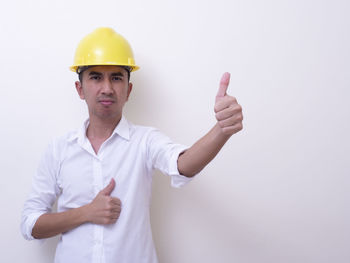 Portrait of young man standing against white background