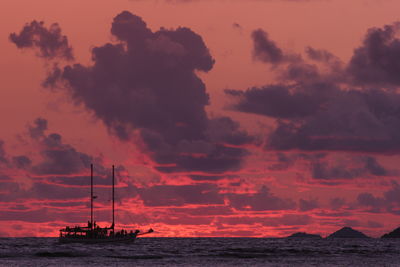 Silhouette sailboat in sea against sky during sunset