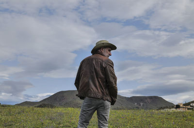 Portrait of adult man in cowboy hat on field