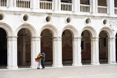 Full length of a man with woman standing in front of building