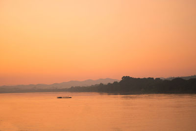 Scenic view of sea against orange sky