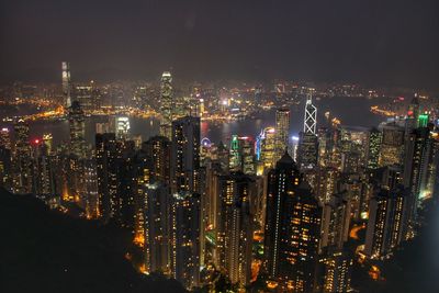 Illuminated cityscape against sky at night