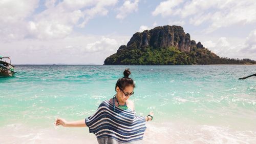 Teenage girl standing against sea at beach