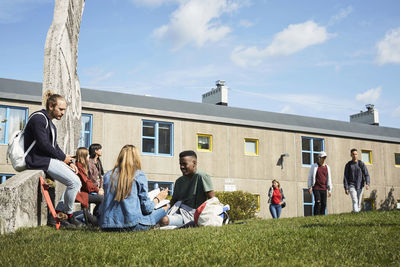 Male and female students against building at university campus