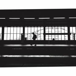 Rear view of silhouette man and woman in window