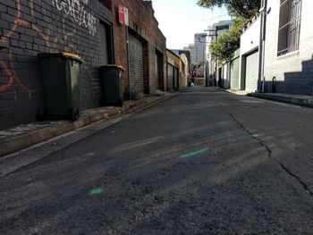 Empty road amidst buildings in city