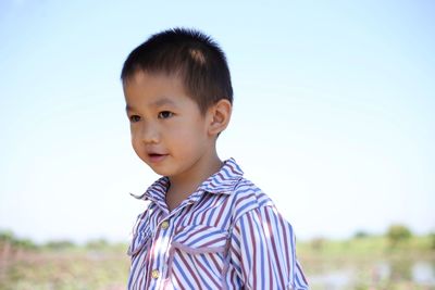 Close-up of cute boy against sky