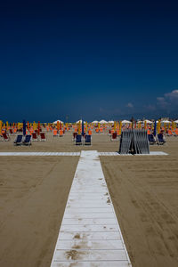 Scenic view of beach against clear blue sky