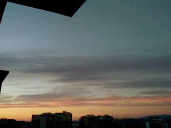 Silhouette buildings against sky at sunset