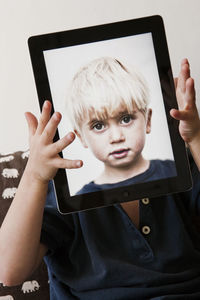 Boy holding digital tablet with his picture