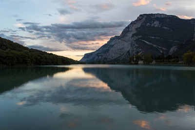 Scenic view of lake by mountains against sky