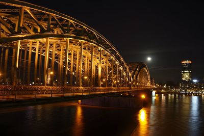 Illuminated bridge over water at night