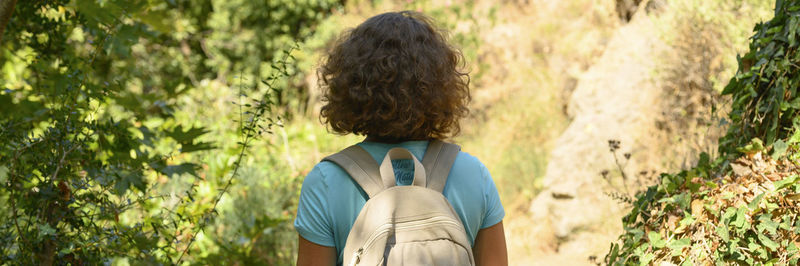 Rear view of woman standing amidst plants