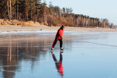 Man skating on the lake in the forest