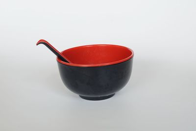 Close-up of red wineglass against white background