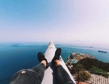 Low section of man sitting on railing