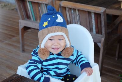 High angle portrait of cute baby wearing warm clothing while sitting on high chair