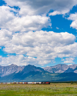 Scenic view of field and mountains against sky