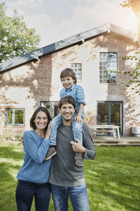 Portrait of happy family with son in garden of their home