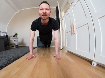 Portrait of mature man sitting on hardwood floor at home