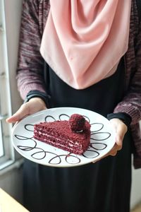 Midsection of person holding chocolate cake